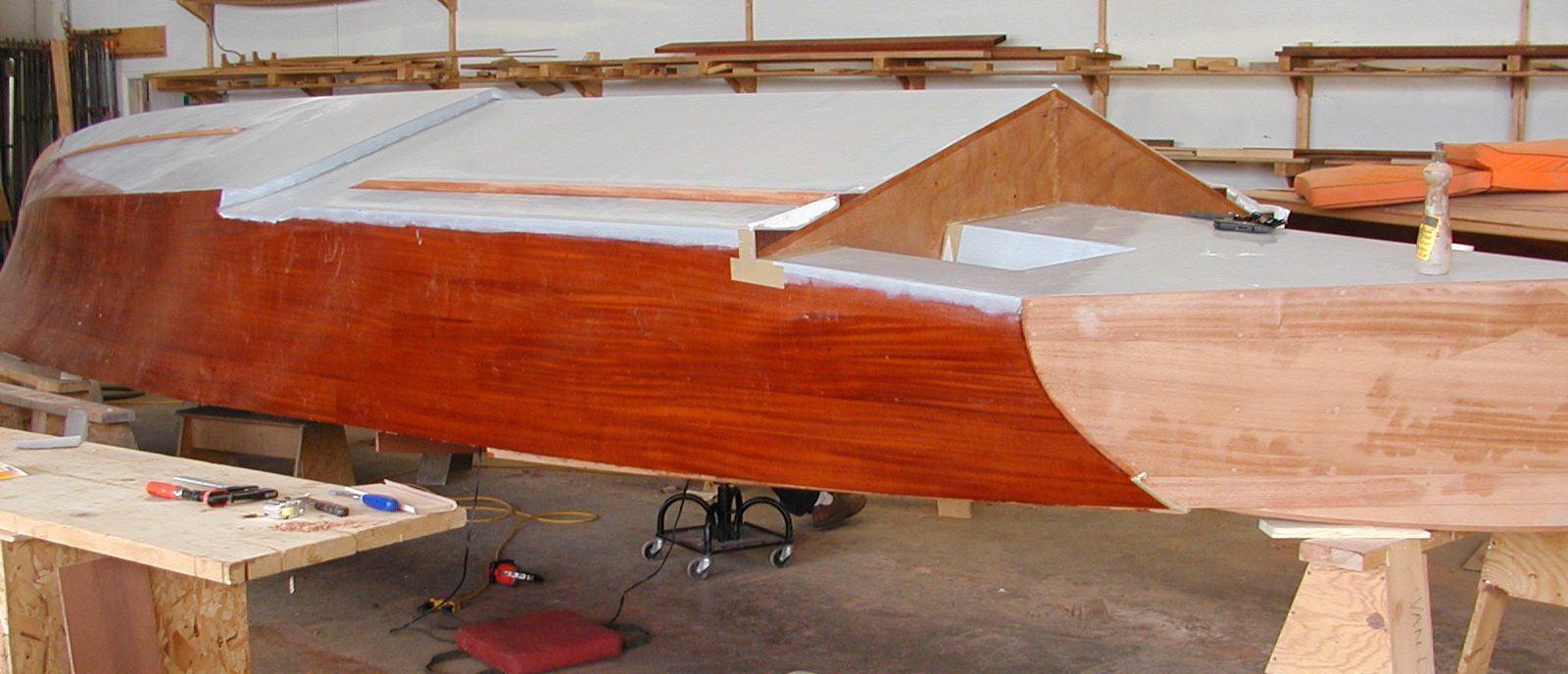 Applying fiberglass cloth to hull of Jacqueline before painting
