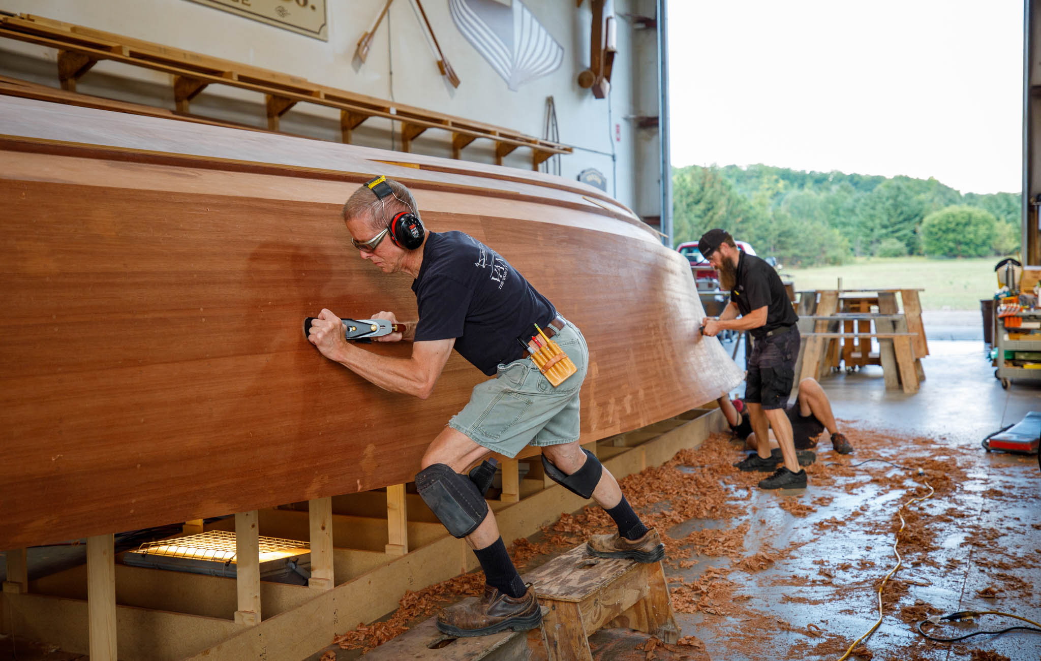 Van Dam's Woodshop Crew fairing the hull of 5-Star